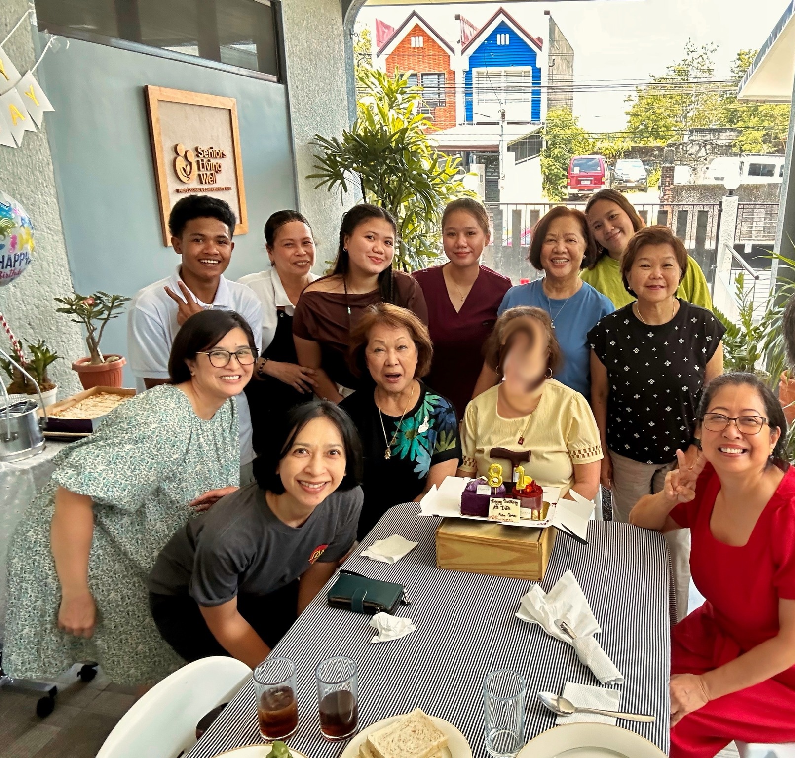 A resident celebrating her birthday with family and staff at Seniors Living Well