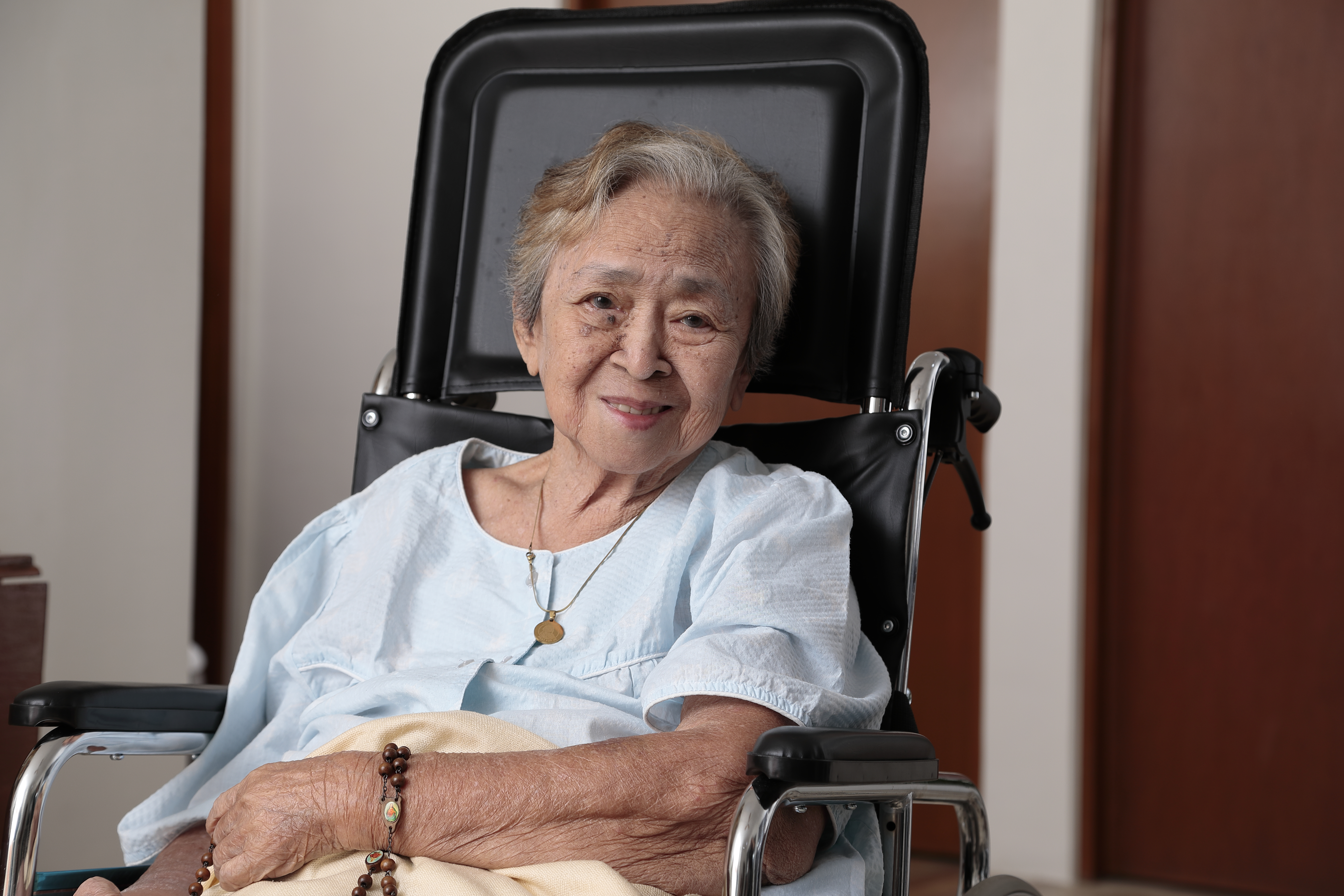 A resident at Seniors Living Well — rosary in hand, at peace